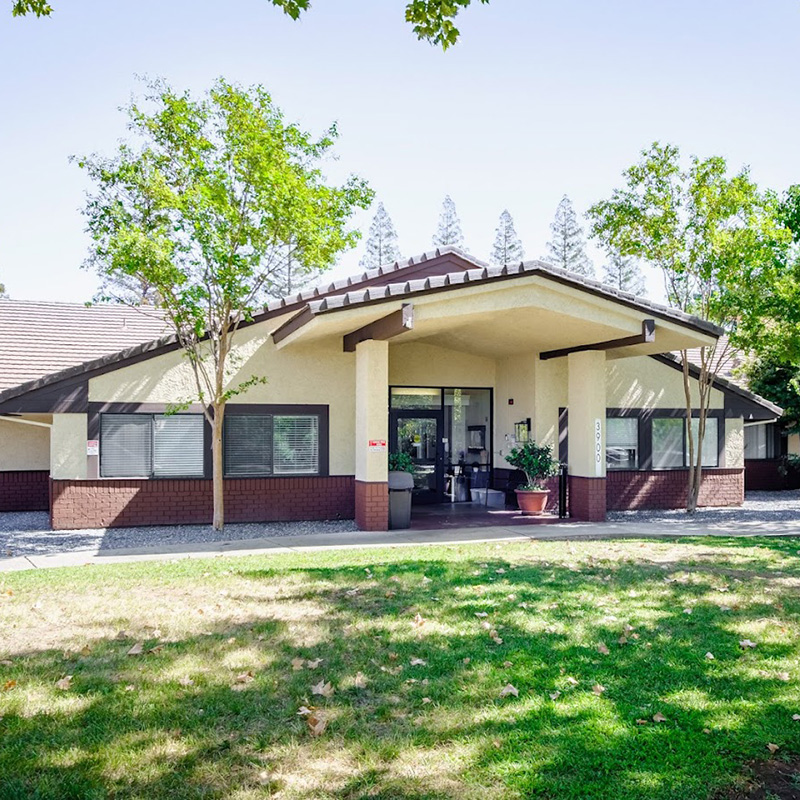 The front of the American River Center showing green grass and trees.